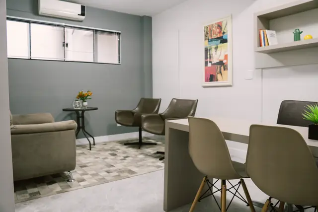 Sala 103 da Willtay em Brusque: mesa com cadeiras, par de poltronas giratórias e janela