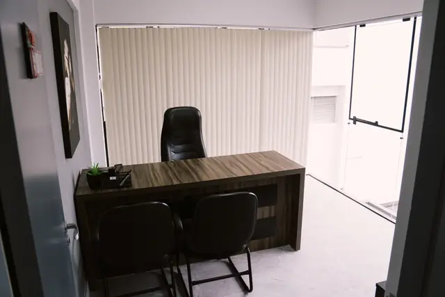 Sala 209 da Willtay em Brusque: mesa de madeira com cadeira executiva e cadeiras para visitantes