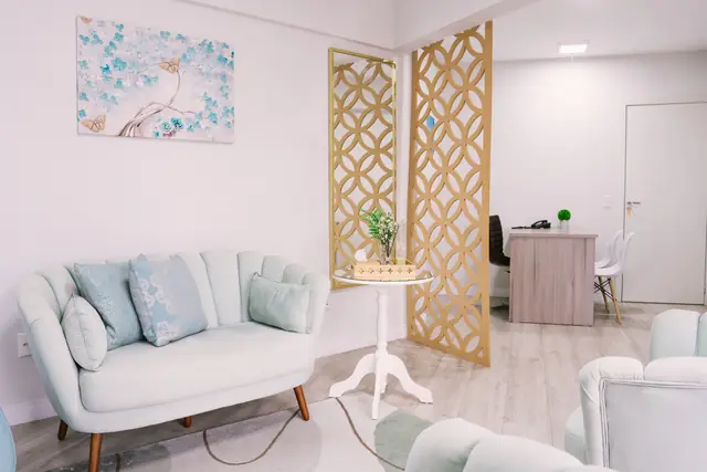 Sala 211 da Willtay em Brusque: estar com sofá e poltronas, separado da mesa por uma divisória vazada